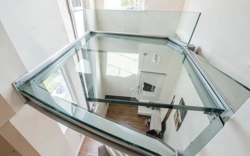 Piso de vidro laminado estrutural com moldura de alumínio em mezanino residencial