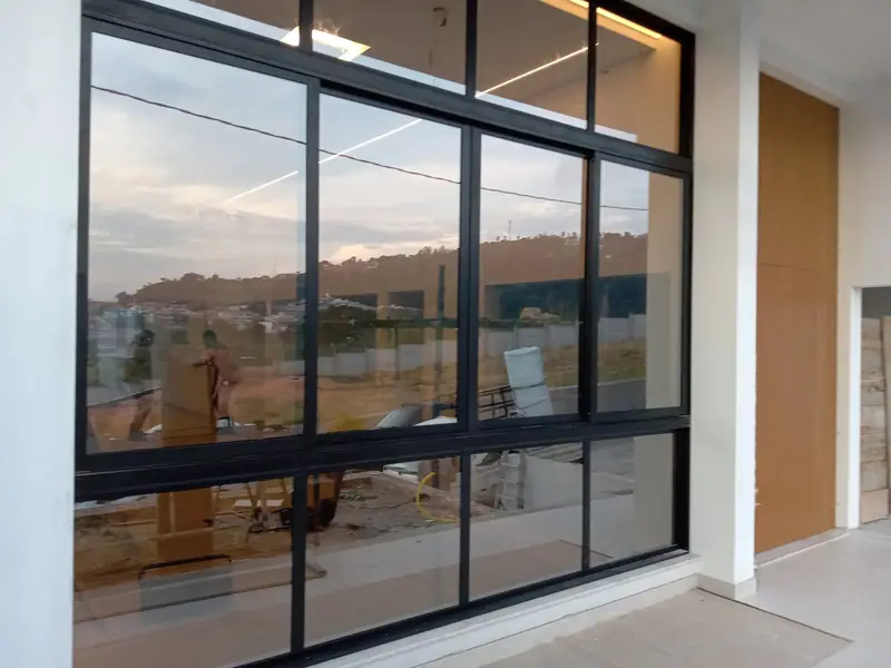 Pele de vidro com perfis pretos em fachada residencial contemporânea