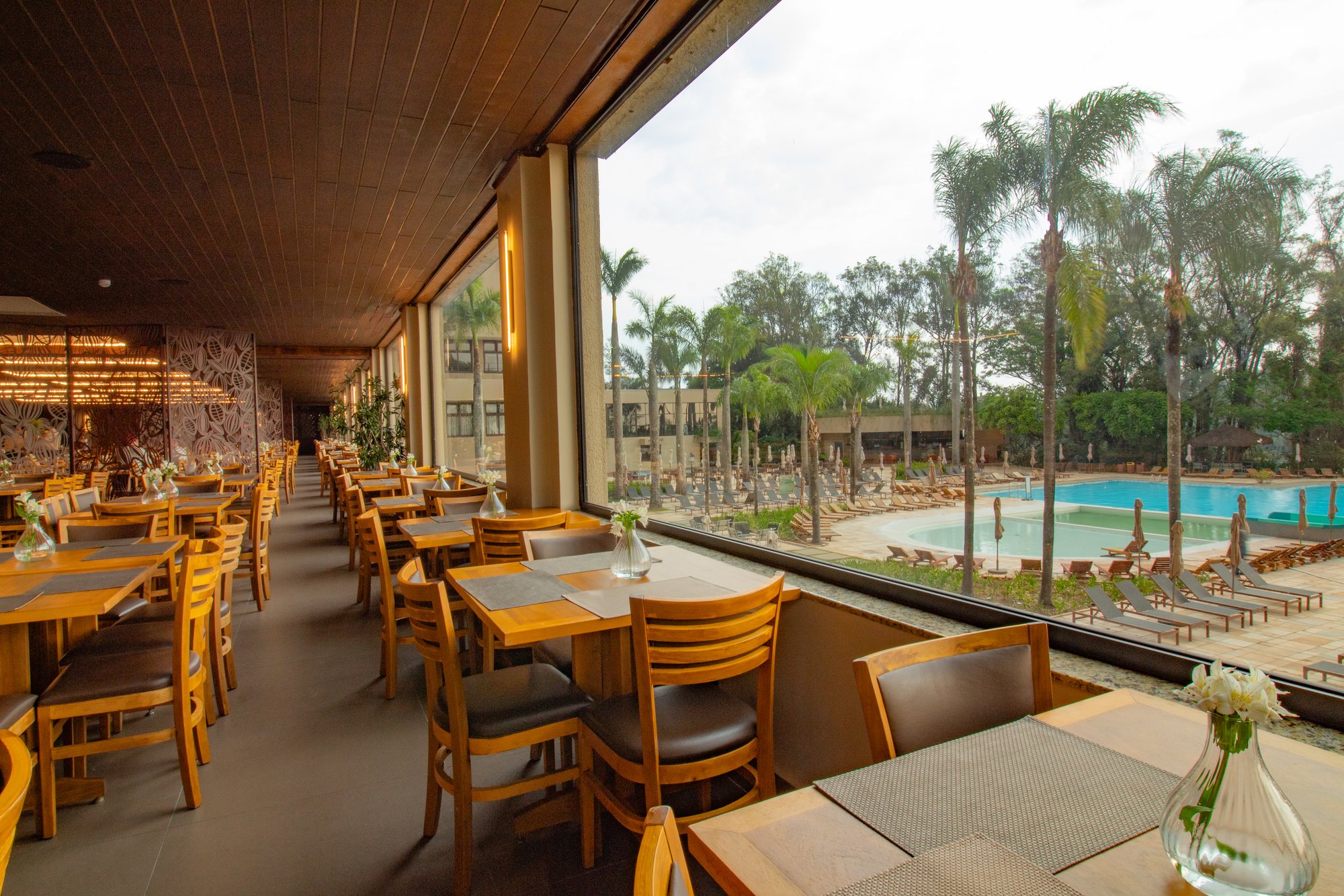 Vista da piscina através do vidro fixo panorâmico do restaurante Bendito Cacao