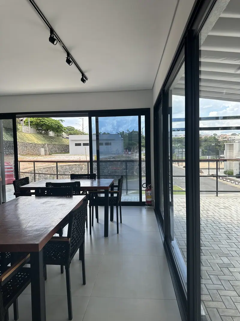 Salão com portas de correr de vidro integrando o ambiente interno ao deck externo
