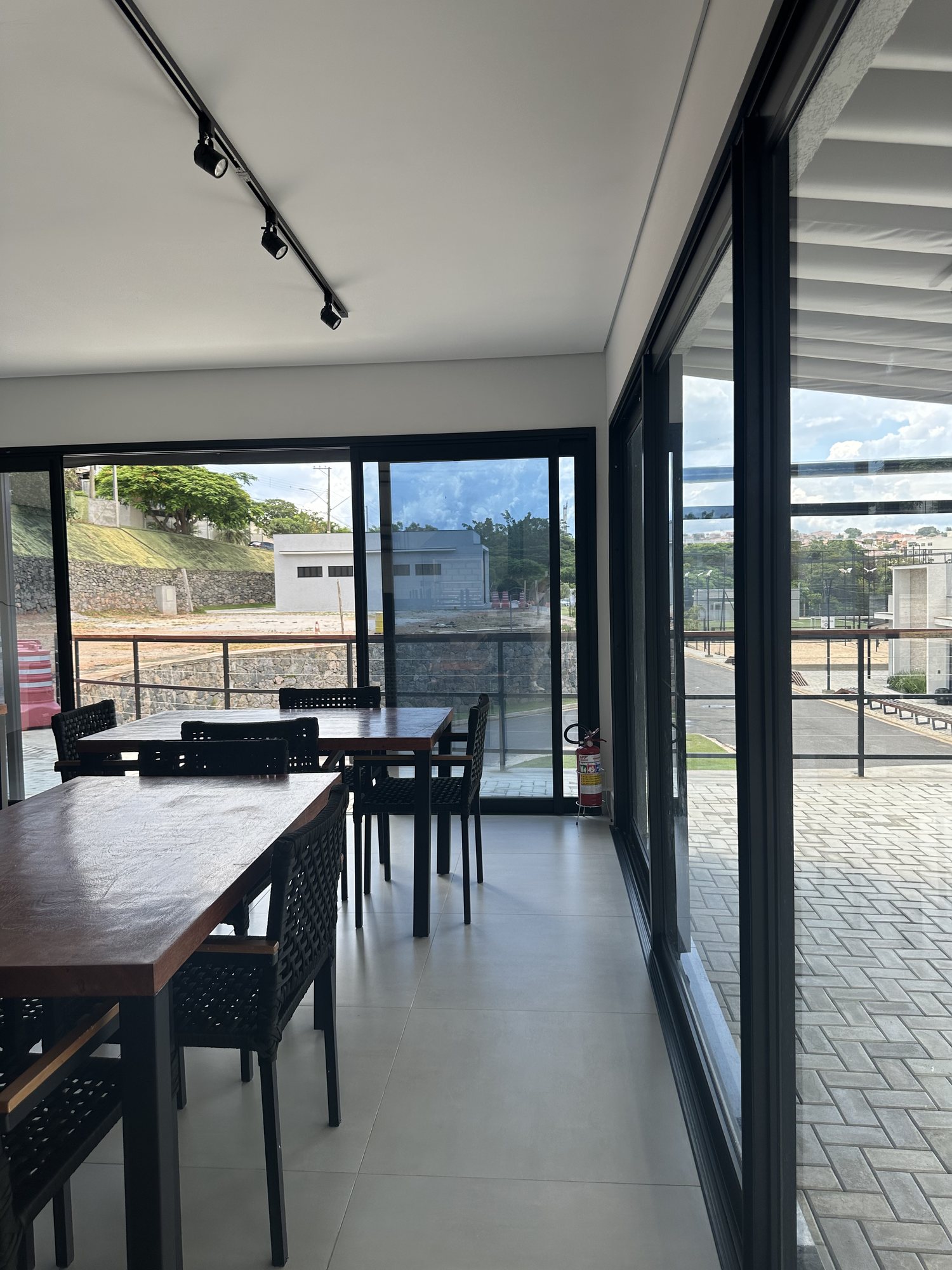 Salão com portas de correr de vidro integrando o ambiente interno ao deck externo
