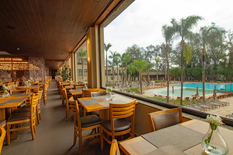 Vista da piscina através do vidro fixo panorâmico do restaurante Bendito Cacao