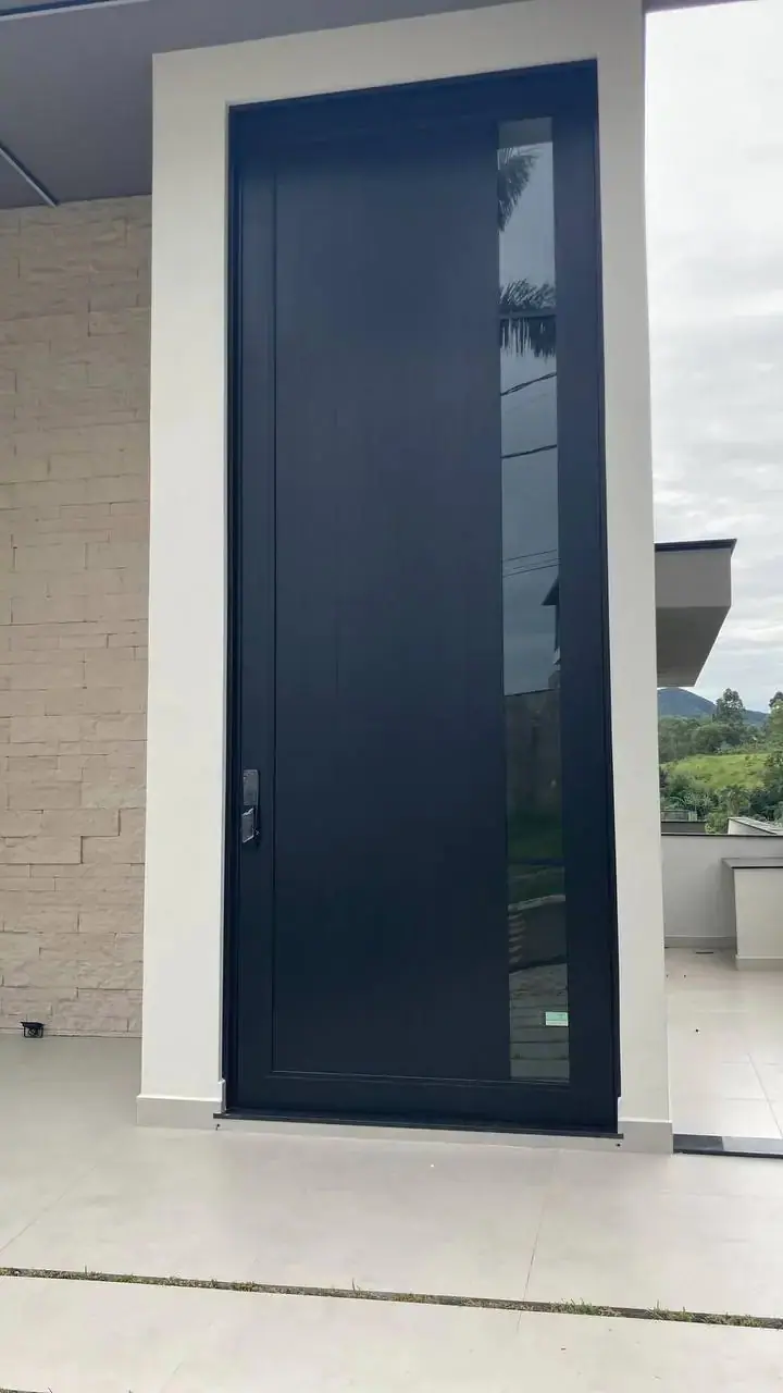 Porta de entrada em alumínio com acabamento amadeirado e puxador em inox