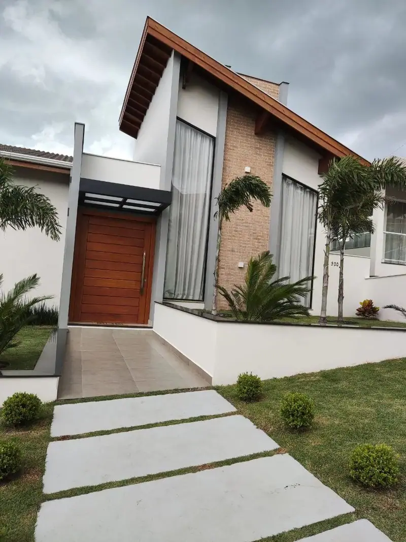 Fachada com portão ripado em alumínio amadeirado