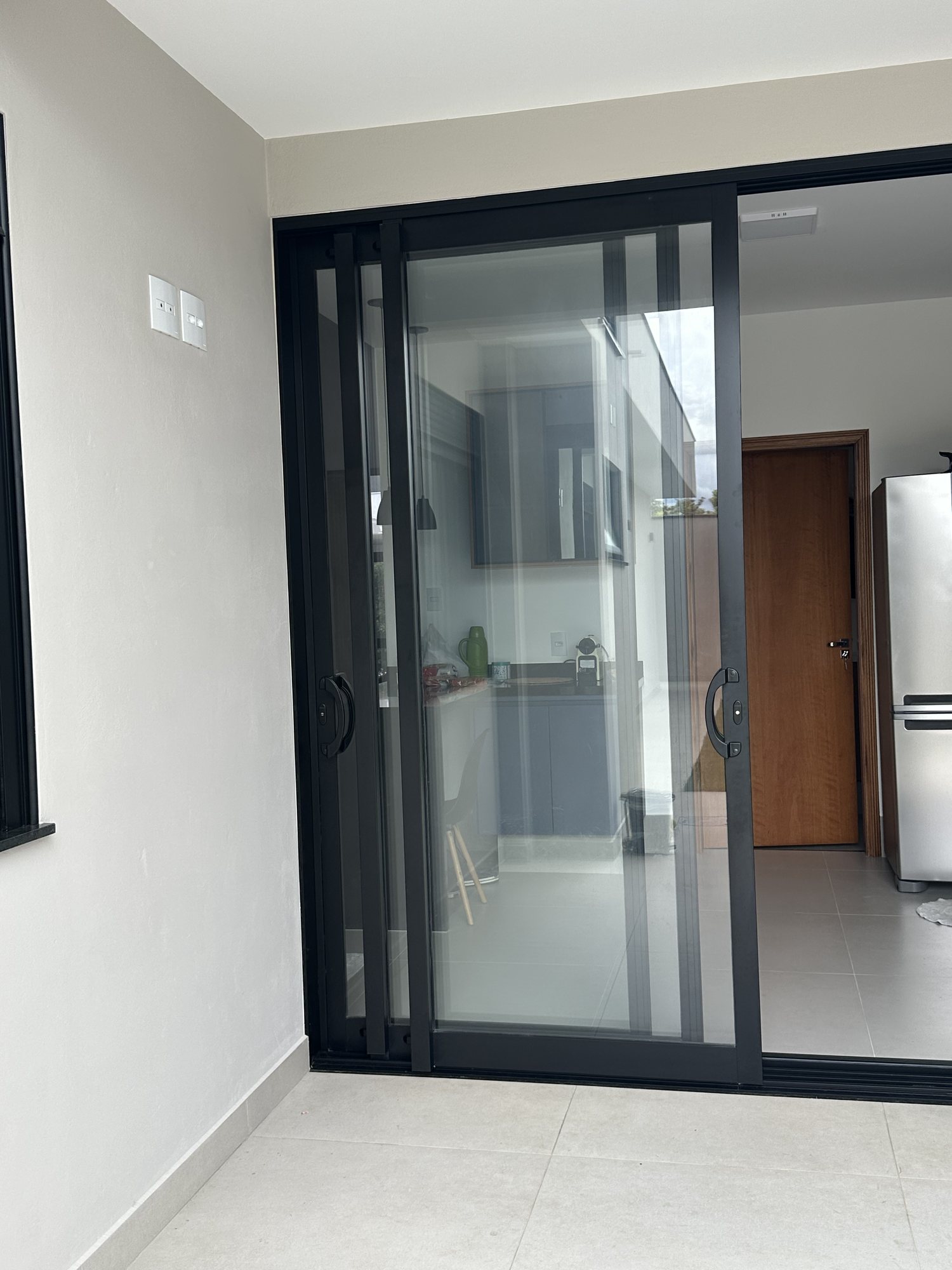 Porta de correr de vidro integrando a cozinha à área externa da residência