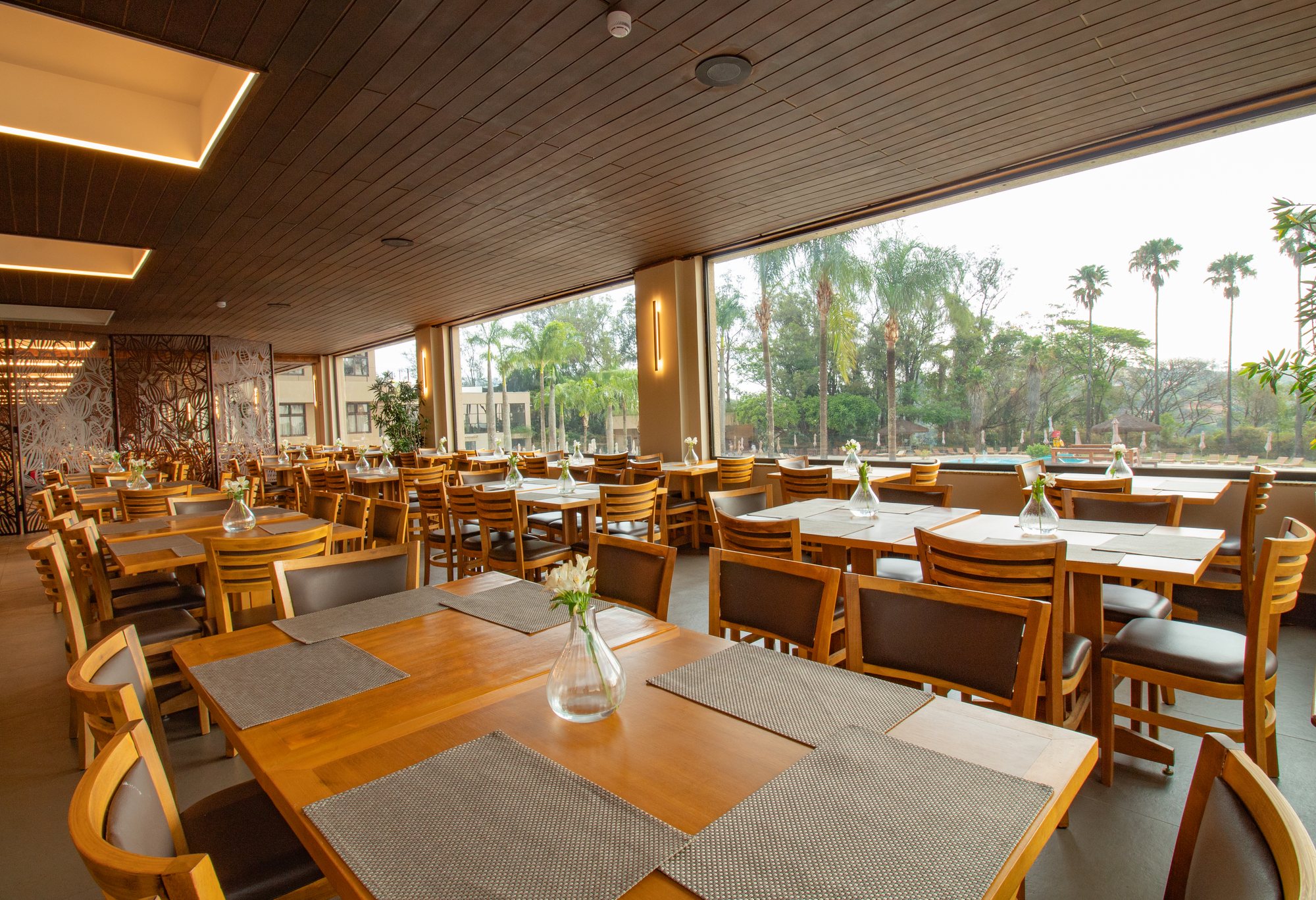 Vidros fixos panorâmicos integrando o salão à área externa do restaurante Bendito Cacao
