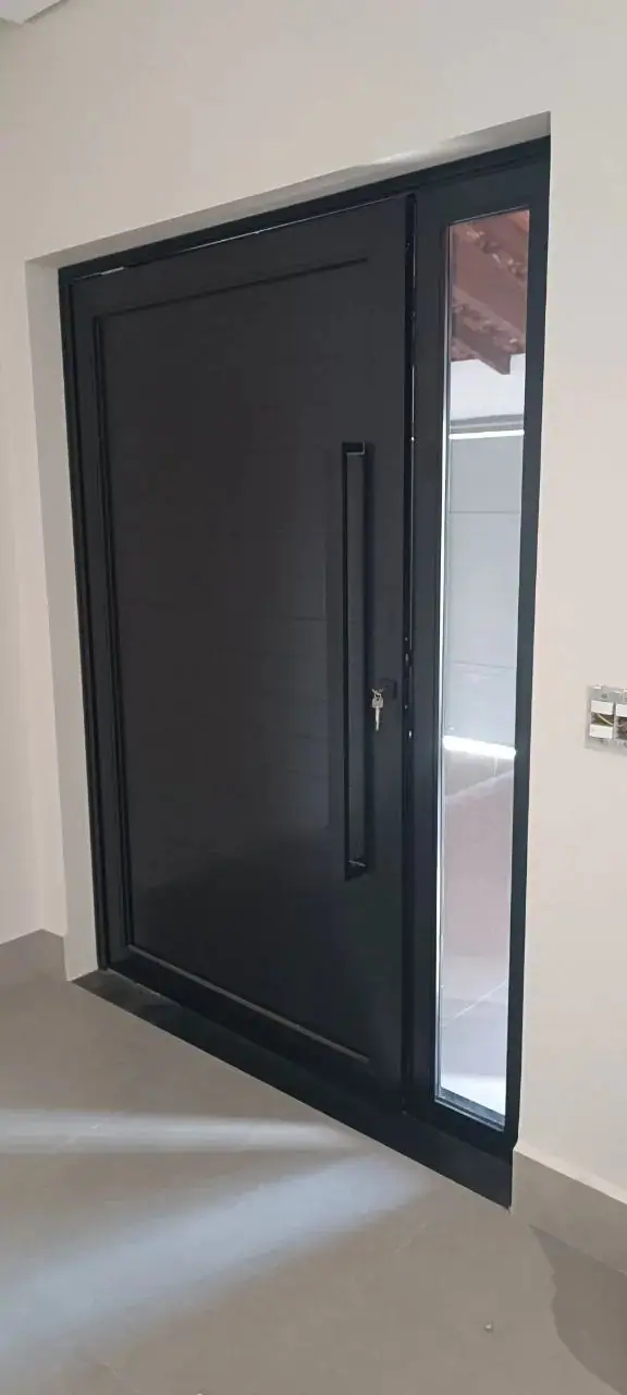 Porta pivotante de alumínio ripado em fachada de alto padrão