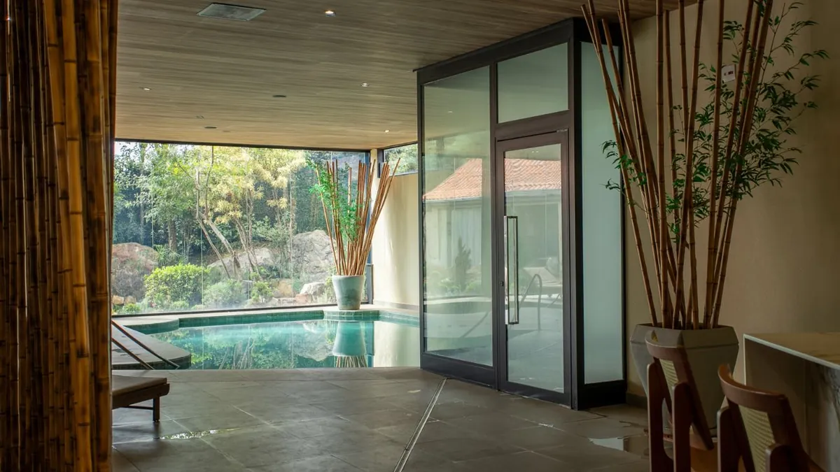 Área de piscina com esquadrias de alumínio integradas à paisagem