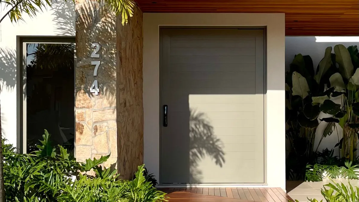 Entrada moderna com porta pivotante e numeração elegante